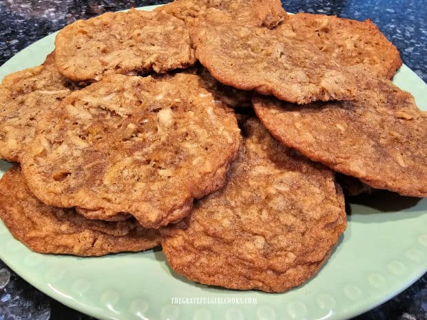 A green plate filled with chewy coconut maple cookies ready to be eaten.