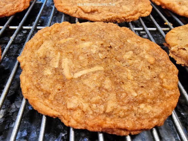 A cookie filled with shredded coconut and pecans, cooling on a wire rack.