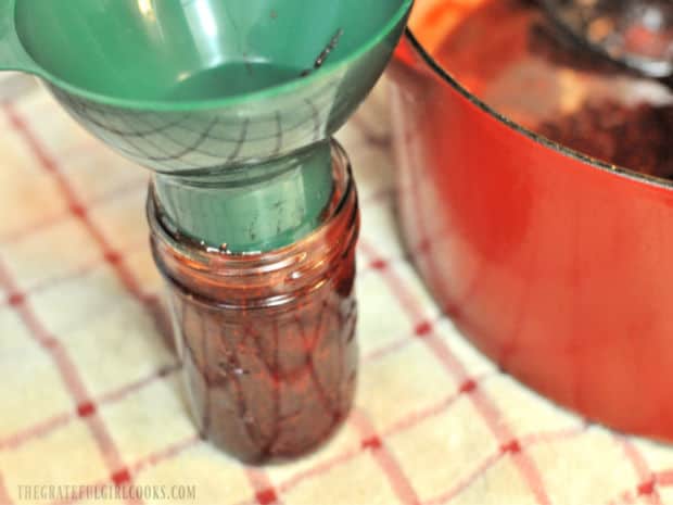 Hot jam is ladled through a canning funnel and into jars.