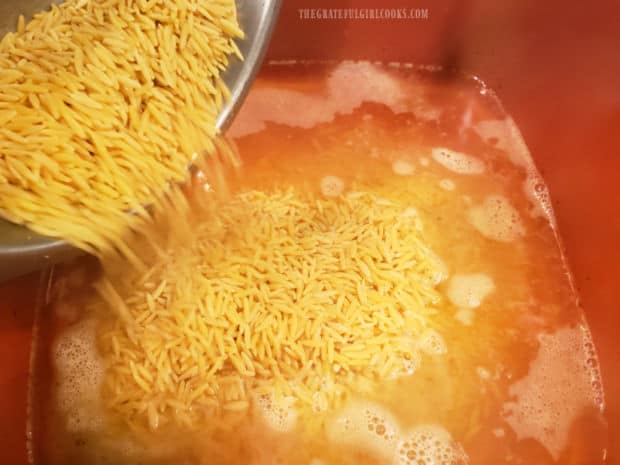Orzo pasta is cooked in boiling water, then drained well.