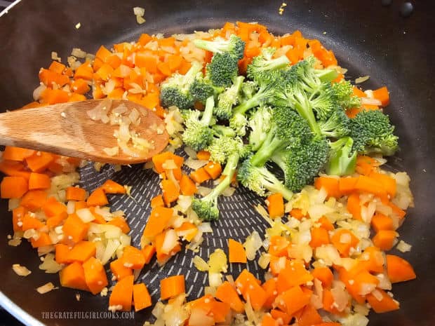 Broccoli florets are added to the veggie mixture in the skillet.