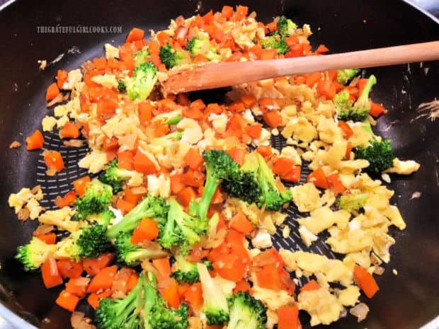 Cooked veggies are added back into skillet with the scrambled eggs.