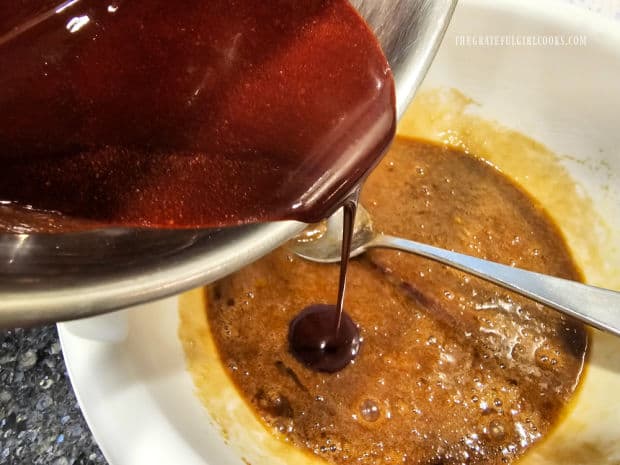 Cooled chocolate butter sauce is slowly drizzled into batter.