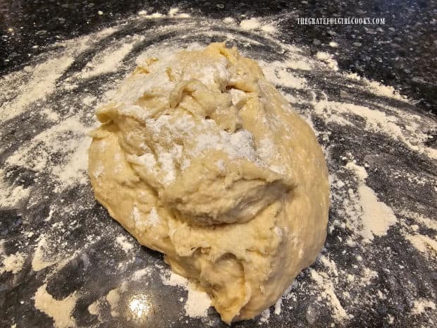 Soft dough on floured surface, ready to be kneaded.