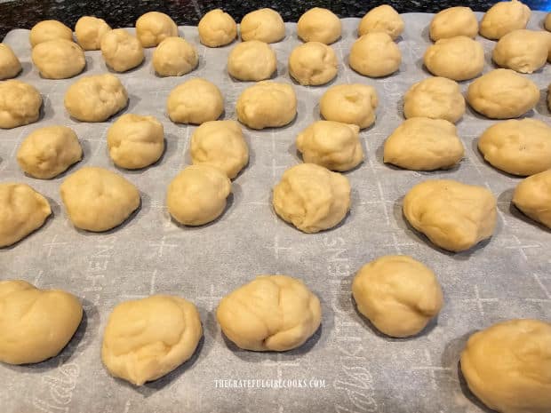 The dough is divided into 72 small balls and placed on parchment paper.