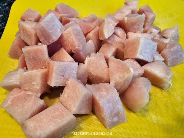 Boneless, skinless chicken breasts are cut into 2" cubes.