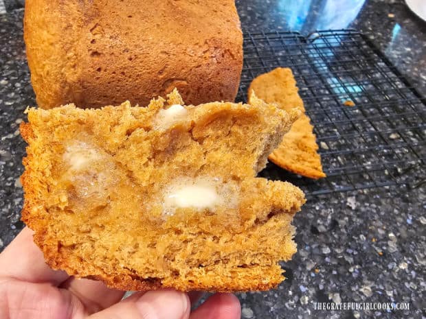 Melted butter is spread on the warm slice of bread.