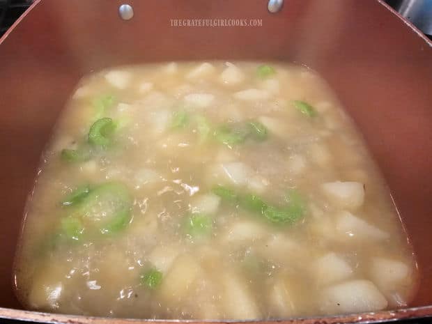Potatoes, onions and celery are now tender in the saucepan.