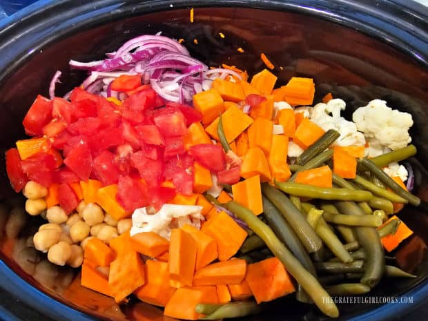 Seven types of vegetables are prepped then put in a slow cooker.