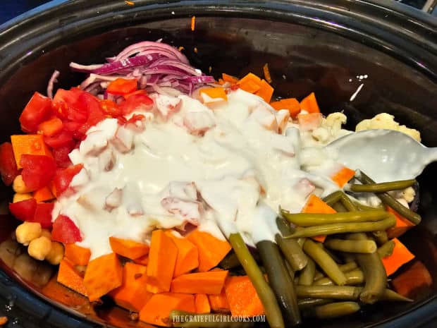 Coconut milk and vegetable broth are added to the slow cooker.