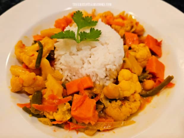 Slow Cooker Veggie Curry is served with white rice in the middle of the bowl.