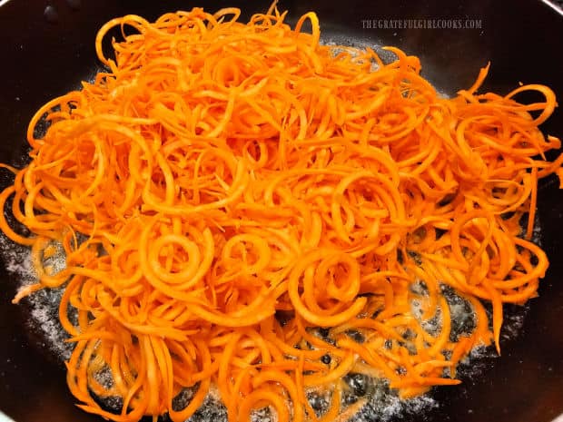 The spiralized sweet potato noodles are added to browned butter in skillet.