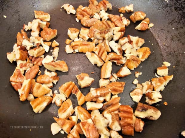 Chopped pecans are lightly toasted in a dry skillet.
