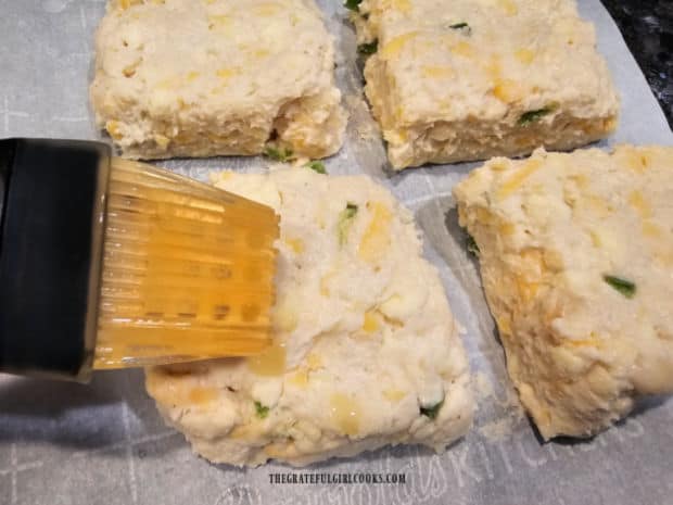 Four biscuits brushed on top with melted butter.