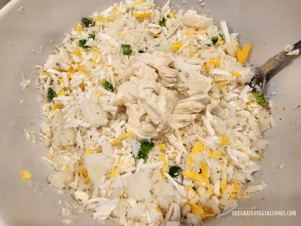 Seasoned sour cream is stirred into the other casserole ingredients in bowl.