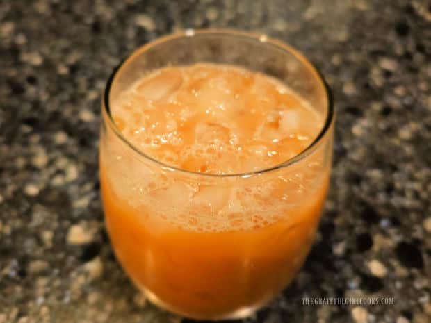 A glass full of a honey almond iced latte before a topping is added.