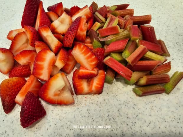 Fresh strawberries and rhubarb are cut into slices, then measured.