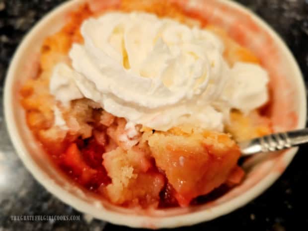 Whipped cream is added to the mini cobbler before serving.