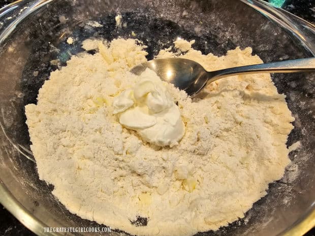 Sour cream is stirred into the crumbly cobbler topping until incorporated.