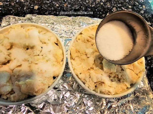 Each mini cobbler is sprinkled with granulated sugar before baking.