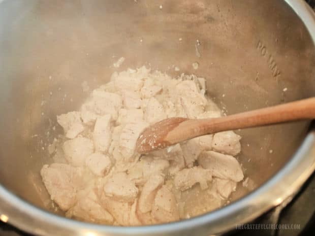 The chicken is cooked until almost done and will finish cooking later.