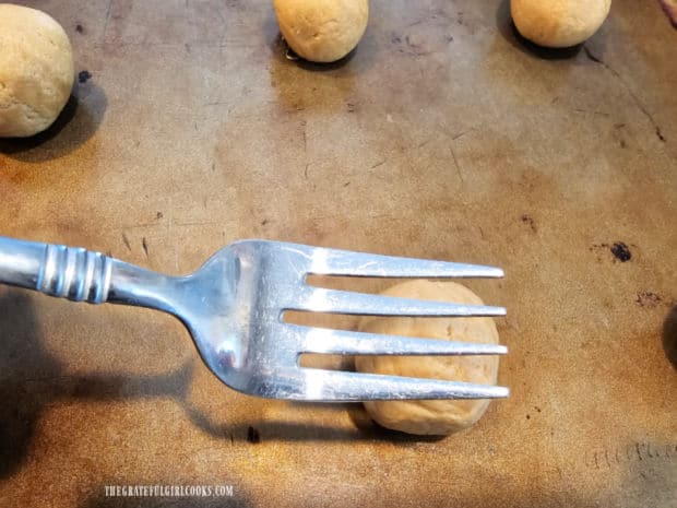 A criss-cross pattern is formed on the cookies using the tines of a fork.