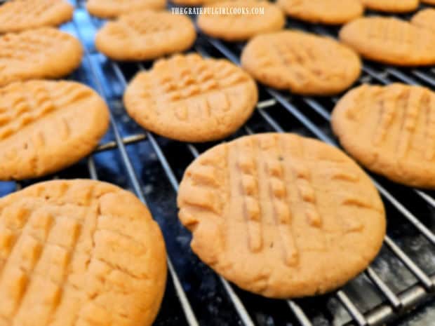 Golden brown peanut butter cookies cooling on a wire rack.