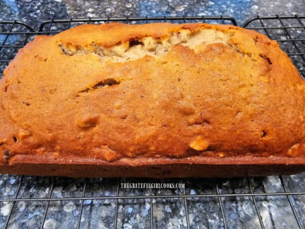Loaf of date nut bread cools on a wire rack after it's removed from pan.