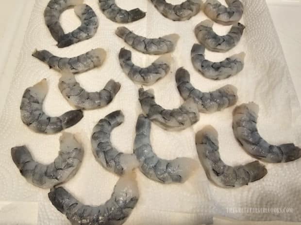 Large shrimp are blotted dry on paper towels before they are cooked.