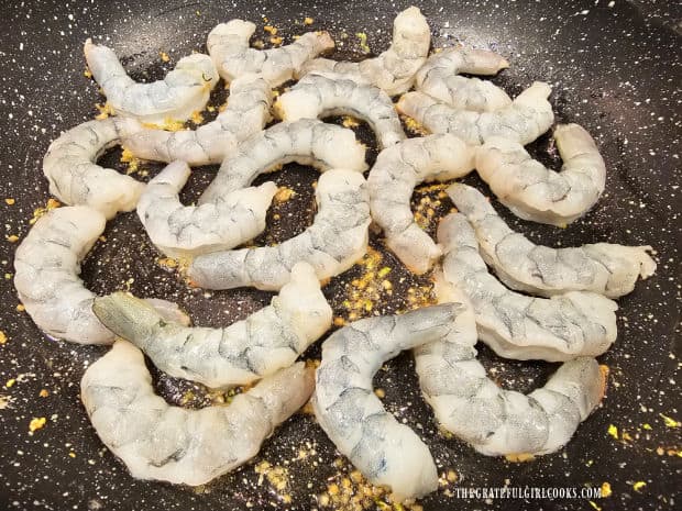 The shrimp are added to the cooked garlic in skillet.