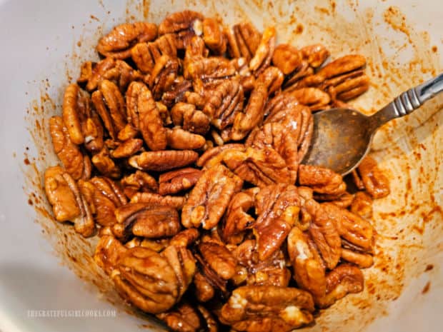 Pecans are stirred, to cover them with the seasoning mix.
