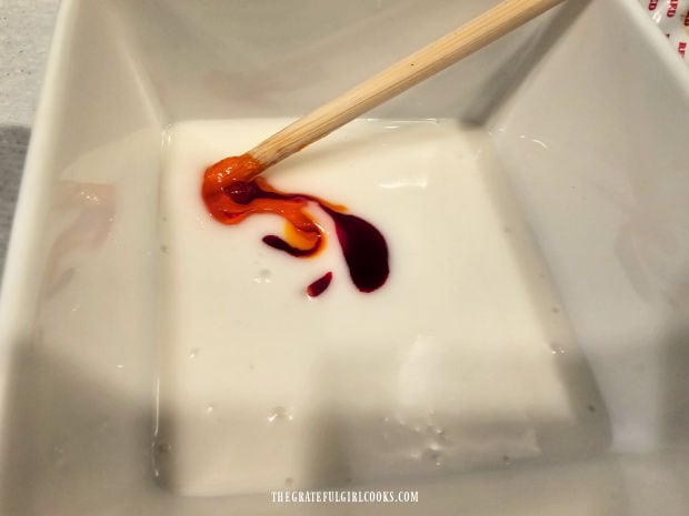 Food coloring is added to the smooth icing in bowls.