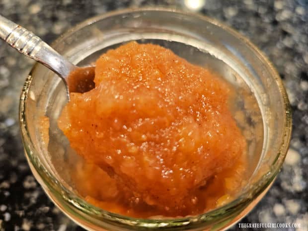 A closeup photo of a spoonful of home-canned applesauce, right out of the jar.