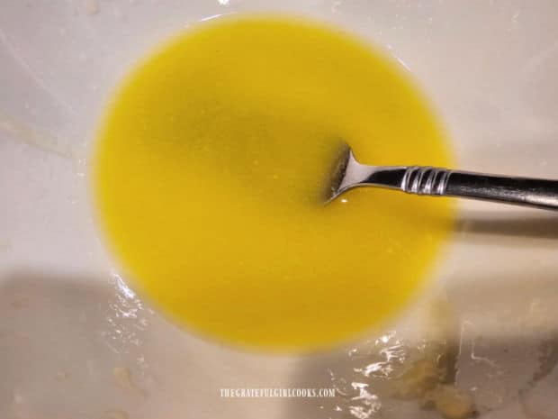 Melted butter and extra virgin olive oil are combined in a small bowl.