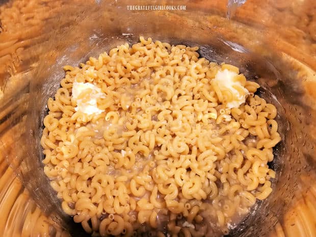 Pasta is pressed down into chicken broth as much as possible before cooking.