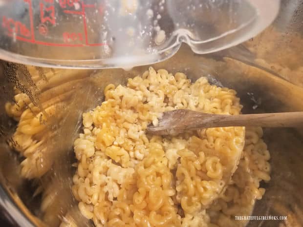The milk mixture is added to the cooked pasta and stirred to combine.