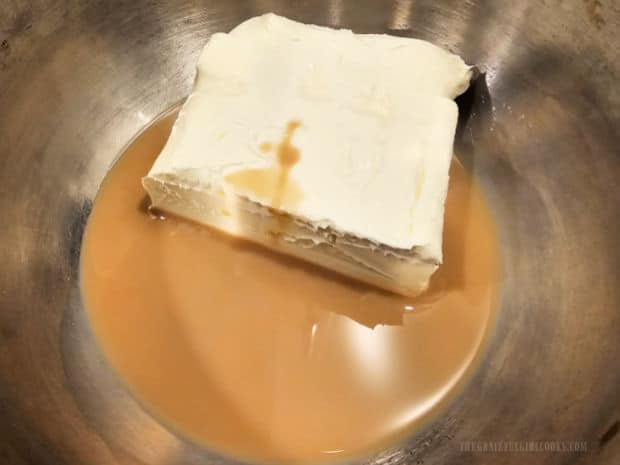 Softened cream cheese and Irish cream liqueur in a small metal bowl.