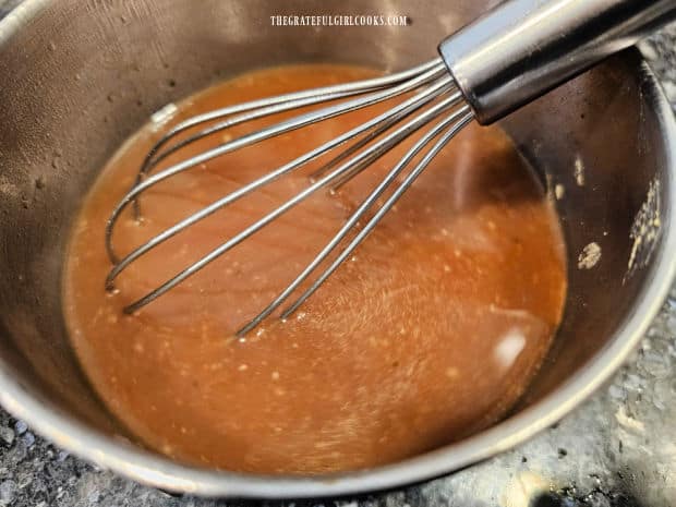 Broth, soy sauce, maple syrup and Dijon are whisked together in a bowl.