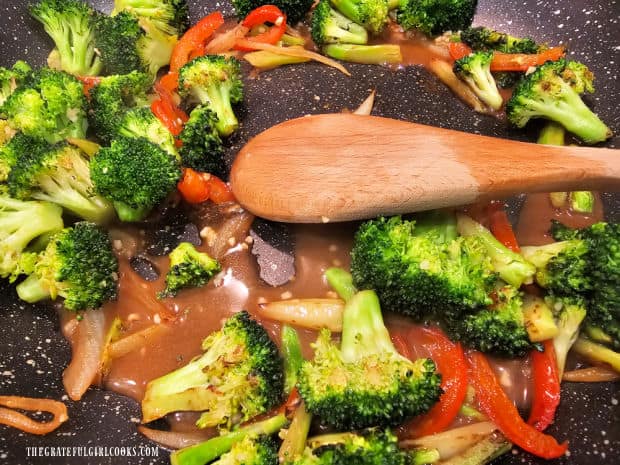 Sauce is cooked until thickened, coating the veggies in the skillet.