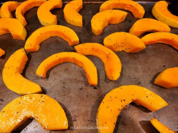 The butternut squash slices in a single layer on baking sheet, ready for oven.