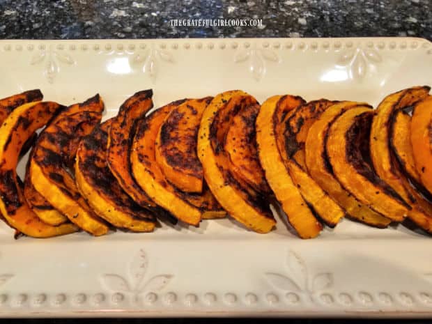 Roasted squash slices are "shingled" and arranged on a serving platter before garnishing.