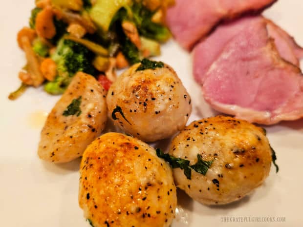 A plate with roasted golden potatoes, ham slices and a broccoli stir-fry.