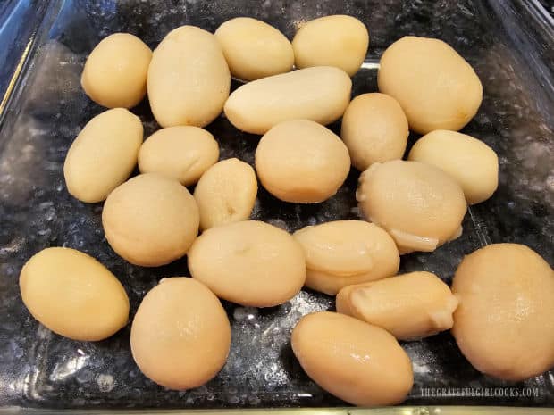 Drained whole potatoes are placed in baking dish in a single layer.