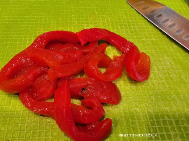 Roasted red peppers are chopped finely after removing them from the jar.