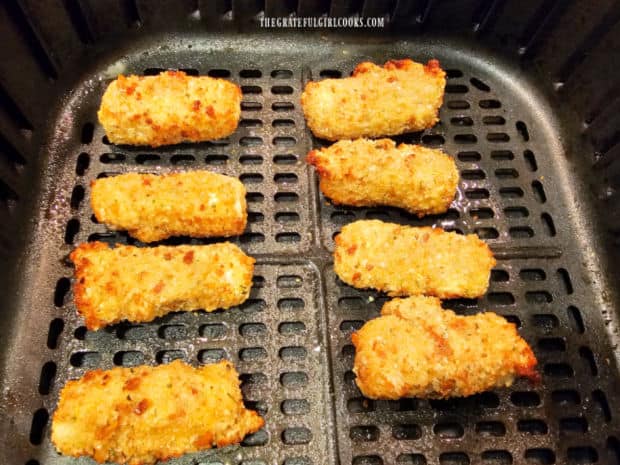 The finished air-fried mozzarella bites are crispy and golden brown after cooking.