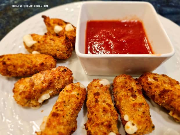 Air-fried mozzarella bites are served hot with warm marinara sauce for dipping.