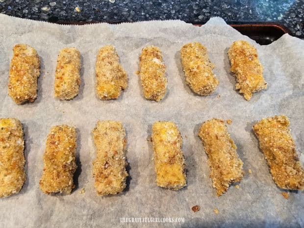 Breaded, seasoned mozzarella sticks are flash frozen on baking sheet for 2 hours.