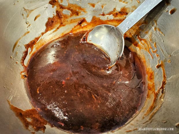 Sauce ingredients are stirred until fully combined in the saucepan.