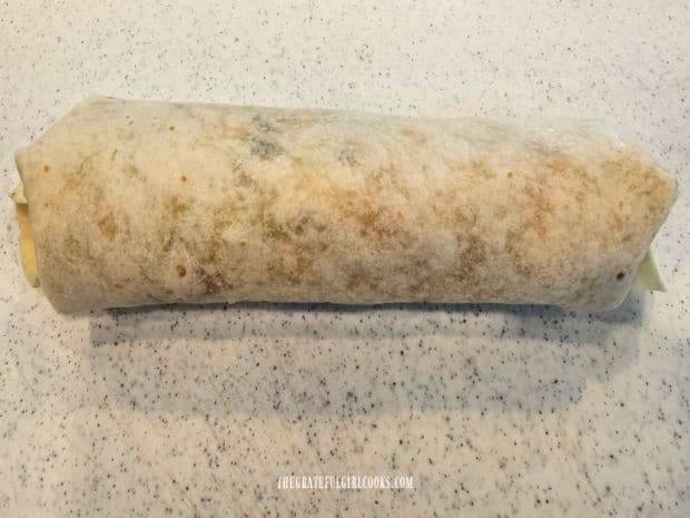 One Greek Chicken Salad Wrap rolled up tightly like a burrito.