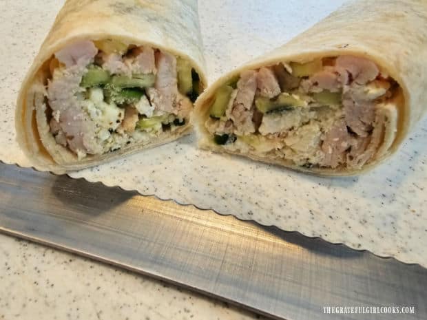A serrated knife is used to slice the wrap in half before serving.